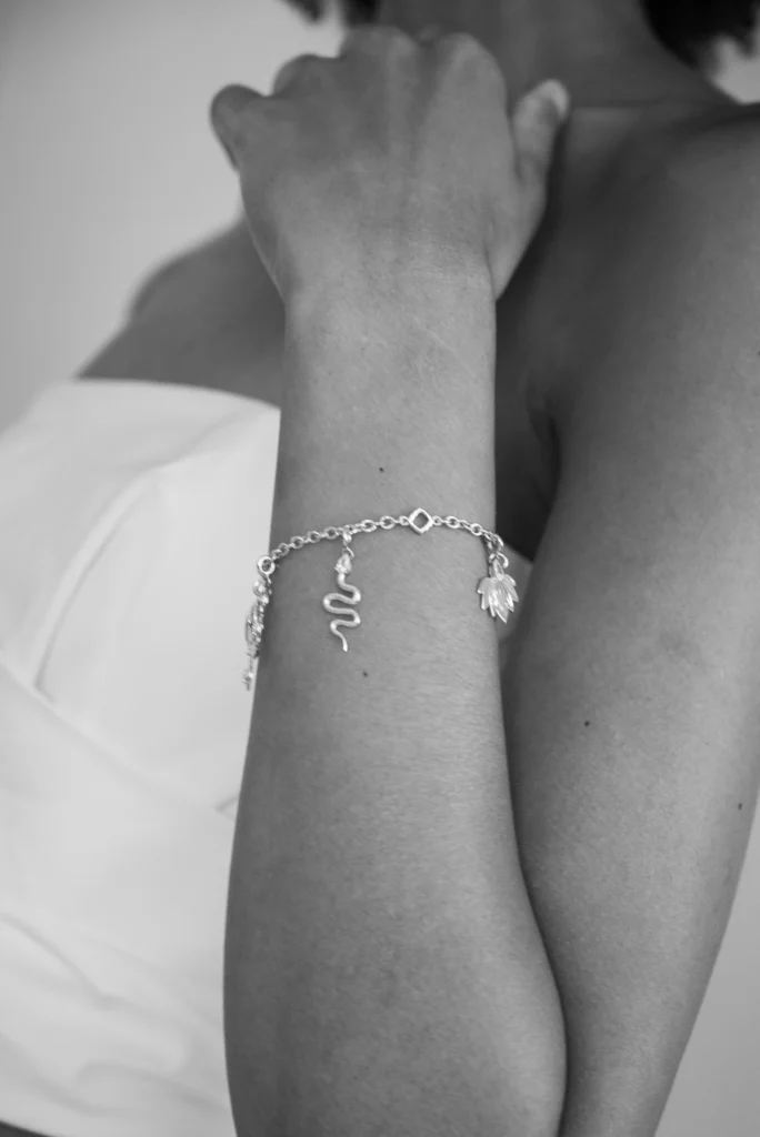 Bracciale Desiderio Siklah con charm serpente in oro indossato al polso, foto in bianco e nero