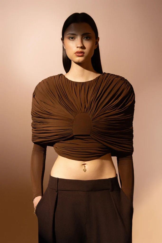 Charm cuore Passione Siklah al piercing dell'ombelico, styling minimal con top marrone.
