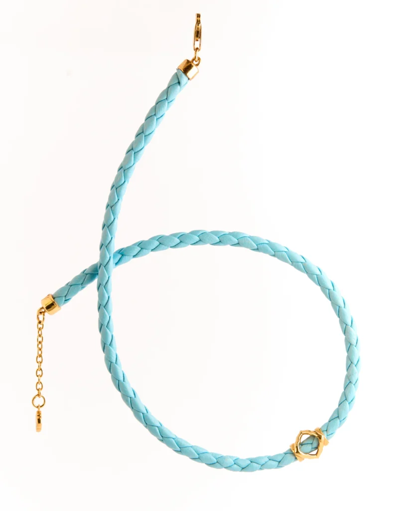 Dettaglio della collana in pelle intrecciata Siklah azzurra con modulo centrale placcato oro
