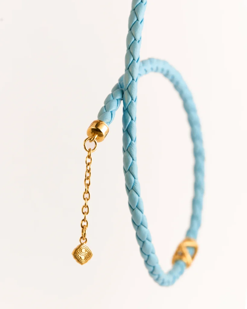 Dettaglio della collana in pelle intrecciata Siklah azzurra con modulo centrale placcato oro