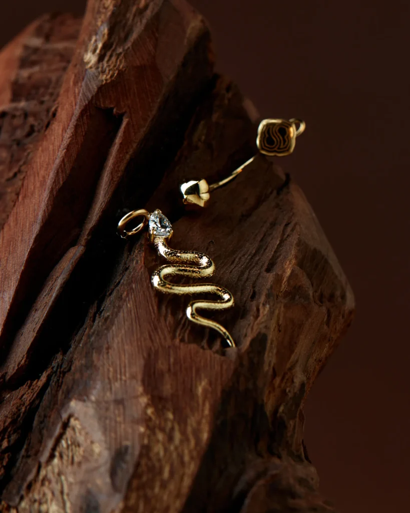 Charm Desiderio a serpente in oro giallo 18 carati Siklah su corteccia scura
