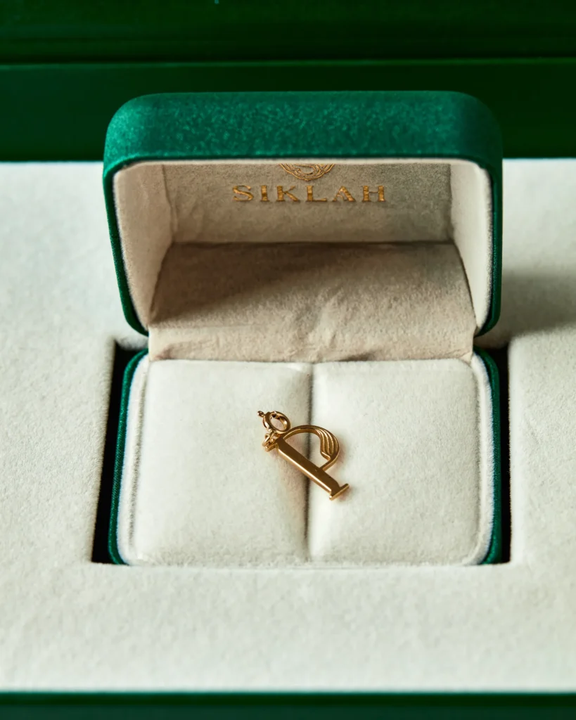 Charm Genesi in oro giallo nella confezione verde smeraldo Siklah con logo inciso