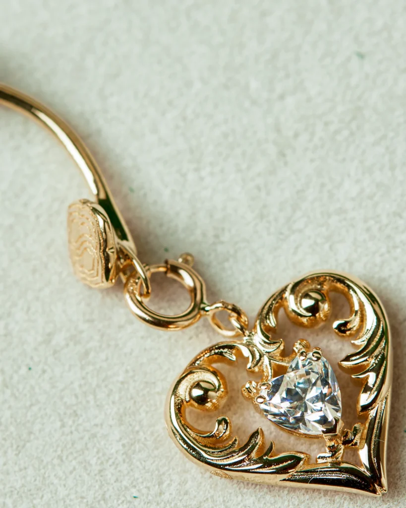 Dettaglio macro del charm Passione Siklah, cuore in oro 18 carati con zircone taglio cuore.