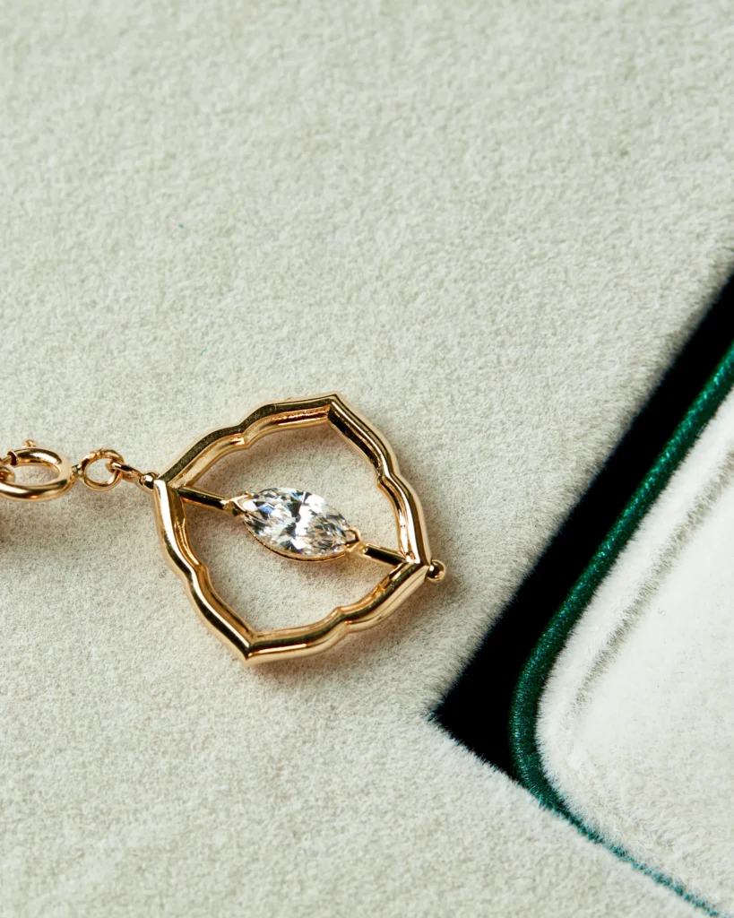 Charm Visione Siklah in oro giallo con pietra taglio marquise, nella confezione verde smeraldo del brand
